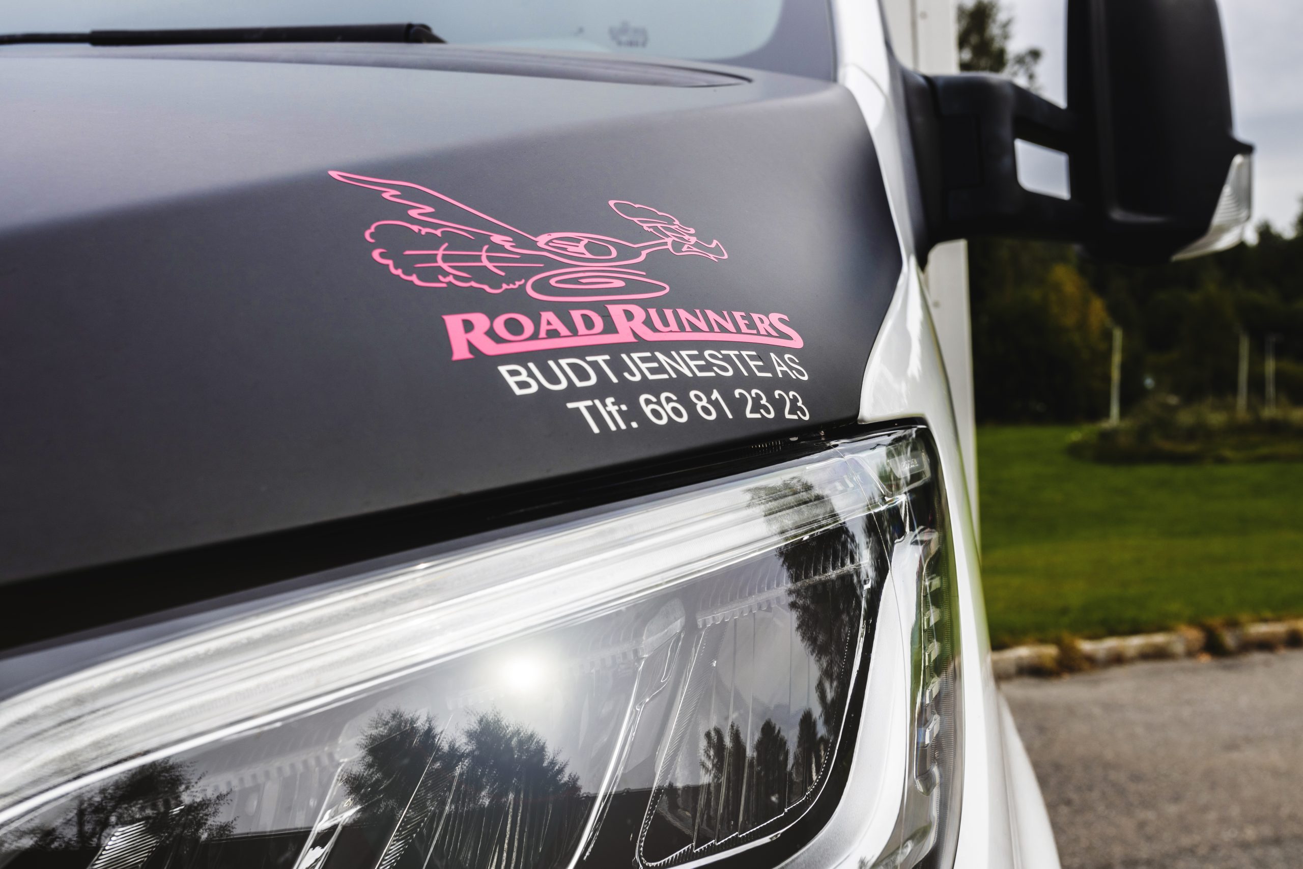 Fronten av en budbil med logoen til Road Runners over lyset.