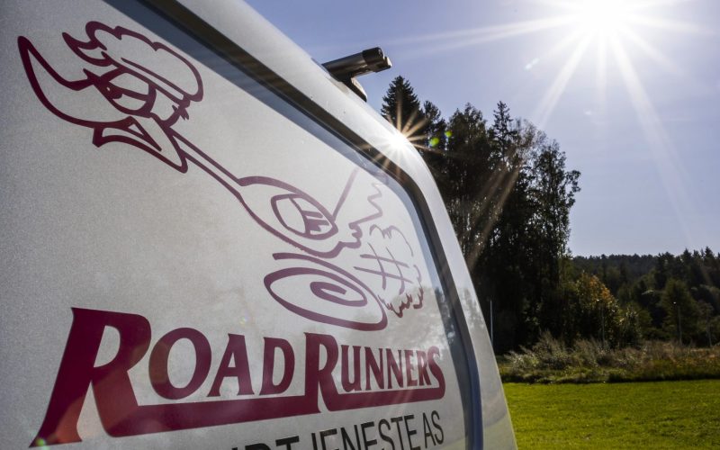 Høyre siden av en hvit budbil med Road Runners logoen.